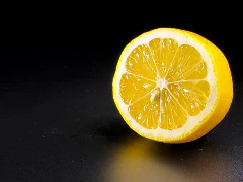 Half lemon on isolated black background close-up Stock Illustration