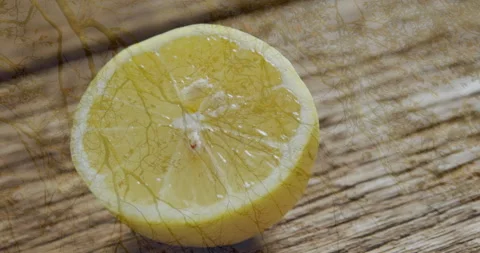 Half lemon with leaf pattern animation on wooden surface, creating artistic Stock Footage 305835524