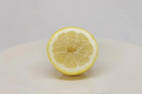 Half of lemon on a white plate. The background is white. Foto stock