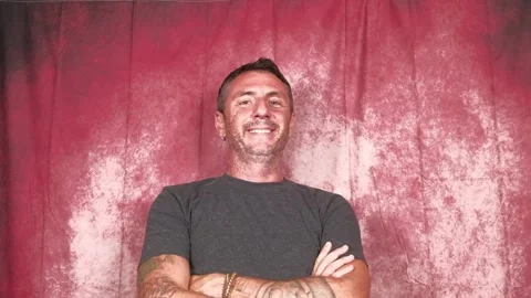 A half-length man smiles in the camera and crosses his arms Stock Footage 341443033