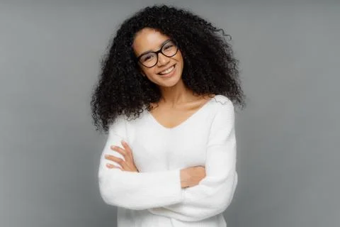 Half length shot of friendly looking African American woman tilts head, has d Stock Photos