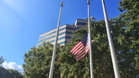 A half-mast US flag at the administrative building Stock Photos