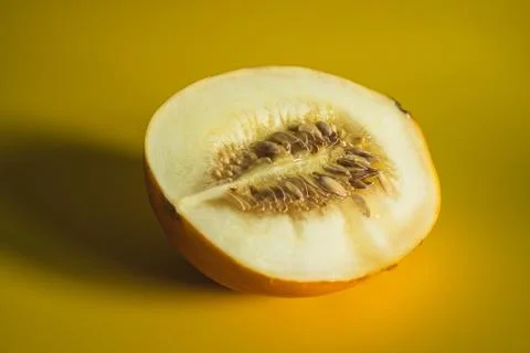 Half of melon on bright yellow background Stock Photos