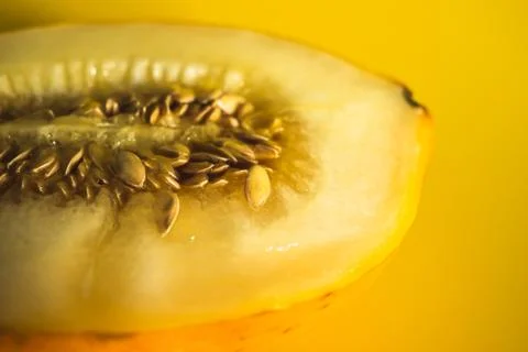 Half of melon on bright yellow background Stock Photos