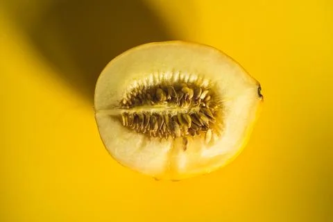 Half of melon on bright yellow background Stock Photos