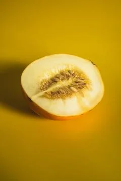 Half of melon on bright yellow background Stock Photos