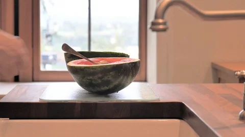 Half melon is lifted off worksurface Stock Footage 116749486