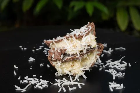 Half a milk chocolate Easter egg with coconut candy filling. Stock Photos