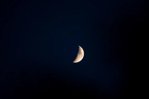 Half moon in a clean dark blue sky Stock Photos