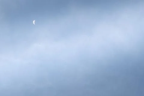 Half-moon during the day, cloudy blue sky. Foto stock