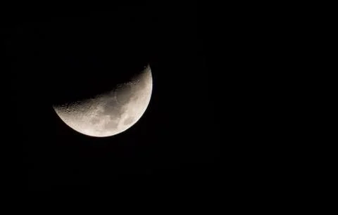 Half moon during the first quarter phase isolated against a black sky. Stock Photos