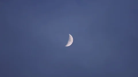 Half moon on early cloudy night with blue sky  Stock Footage 85747219