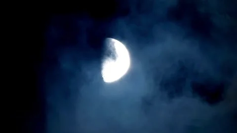 Half moon glowing in night sky with moving clouds Video stock 332281961