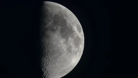 Half moon in the night sky close-up with highly detailed craters and haze clouds Stock Footage 157073082