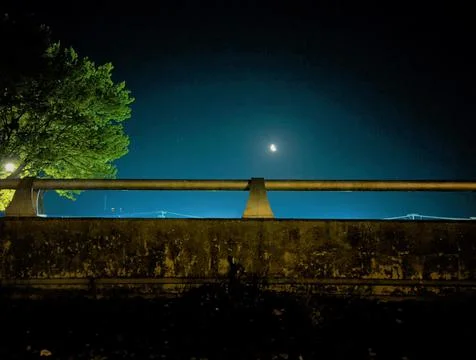 Half moon over train overpass 写真素材