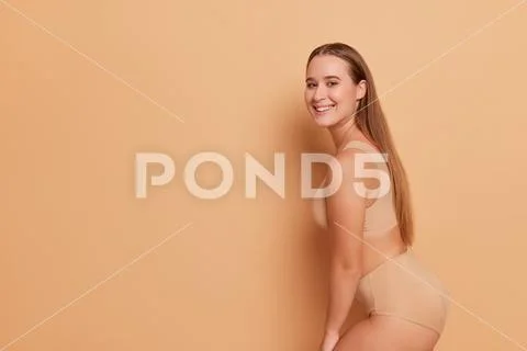 Stock Photo of Young woman sexy half naked body and underwear under a light  beige summer dress Image MXI31979 at