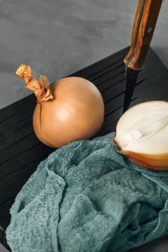 Half of the onion is cut with a knife with a wooden handle Stock Photos