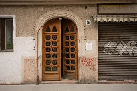 Half open bit arching wooden gate of city flats Stock Photos