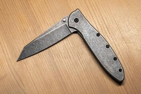 Half-open folded pocket knife featuring stone washed steel parts Photos
