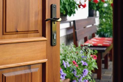 Half opened door into the beautiful summer terrace and  blooming garden Фото