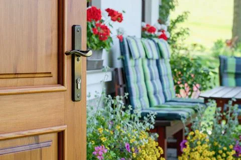 Half opened door into the beautiful summer terrace and  blooming garden 写真素材