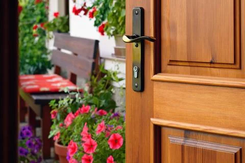 Half opened door into the beautiful summer terrace and  blooming garden Фото