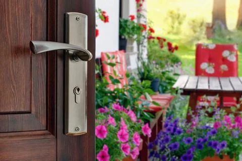 Half opened door into the beautiful summer terrace and  blooming garden 스톡 사진