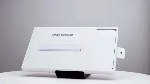 Half opened rotating white package box showing Mac magic trackpad on Stock Footage 174712496