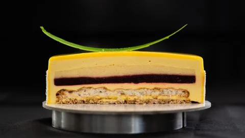Half or slice of mango mousse glazed cake isolated on black background Stock Photos