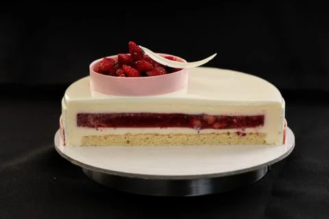Half or slice of white mousse cake isolated on black background Stock Photos