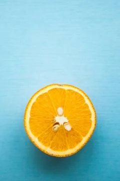 Half of orange on blue background with copy space Stock Photos