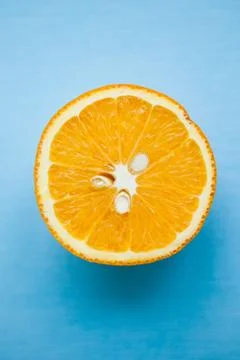 Half of orange on blue background with copy space Stock Photos