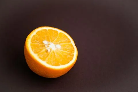 Half of orange on brown background with copy space Foto stock
