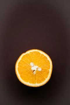 Half of orange on brown background with copy space Stock Photos