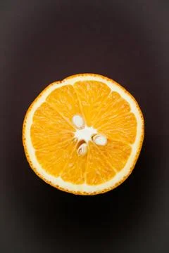 Half of orange on brown background with copy space Stock Photos