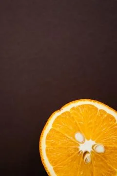 Half of orange on brown background with copy space Stock Photos