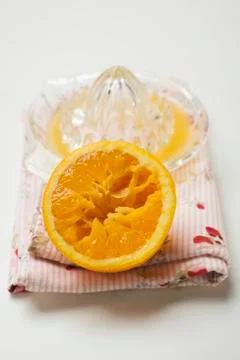 Half an orange in front of citrus squeezer Stock Photos