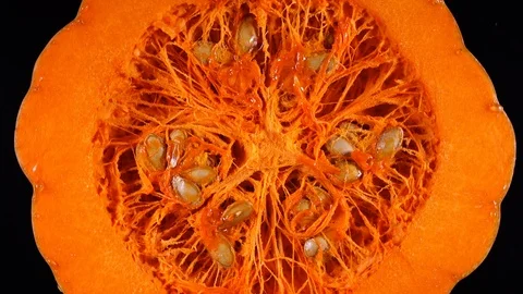 Half of orange raw pumpkin with seeds rotating on black background in 4K 库存影片 87156301