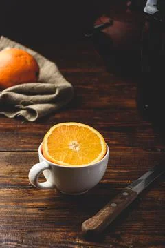 Half of orange in a white cup Stock Photos