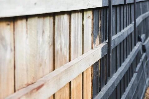 Half painted backyard retaining wall or fence, charcoal vs bare wood, home .. Stock Photos