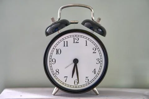 Half past five. The time is 5:30 am or pm. Retro clock isolated wooden table. Foto stock