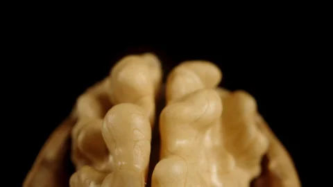 A half-peeled walnut in its shell, on a black background. Dolly slider extreme c Stock Footage 246056966
