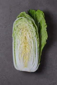 Half of a Peking cabbage in close-up on a gray background. Stock Photos