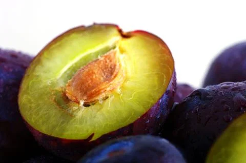Half of plums isolated on white background Stock Photos