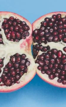 Half pomegranate on a blue background Stock Photos