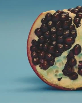 Half pomegranate on a blue background Stock Photos