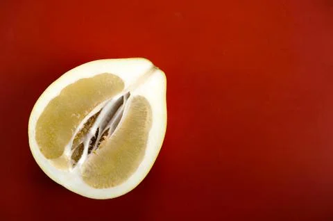 Half a pomelo on a red background Stock Photos