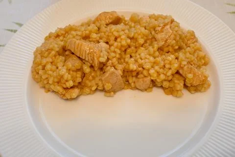 Half portion of rice with meat on a white plate Stock Photos