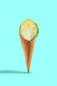 Half a raw cabbage in a wafer cone against turquoise background. Healthy 스톡 사진