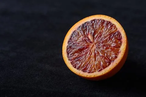 Half of red orange on black background Stock Photos